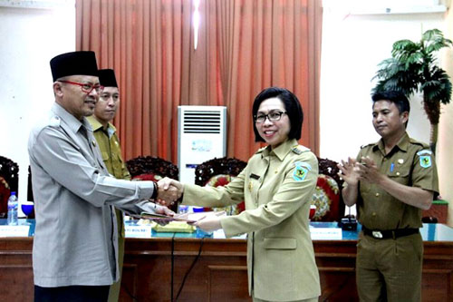 Foto: Bupati Bolmong Dra. Hj. Yasti Soepredjo Mokoagow Dan Bupati Bolsel Hi. Herson Mayulu Saat Saling Berjabat Tangan Dalam Penyerahan Dan Terima Aset