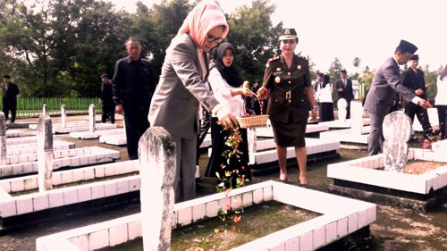 Foto: Ir. Hj. Tatong Bara Saat Menabur Bunga di Salah Satu Makam Pahlawan (TMP) Kotamobagu