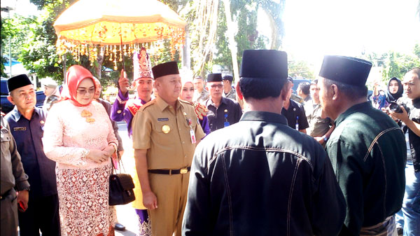 Pejabat Sementara (Pjs) Wali Kota Kotamobagu. Hi. Mohammad Rudi Mokoginta bersama Ny. Hj Y Mokoginta Paputungan Saat di Jemput Oleh Orang Tua Adat